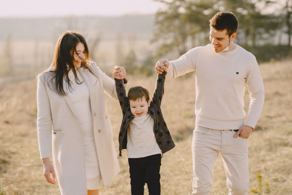 Una familia feliz de tres disfrutando de un día soleado al aire libre en la naturaleza.