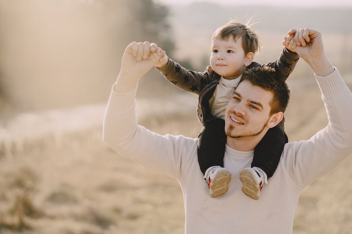 Photo of Man Carrying His Child While Raising Their Hands Up · Free ...