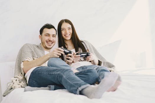 A cheerful couple enjoys playing video games together in a cozy bedroom setting.