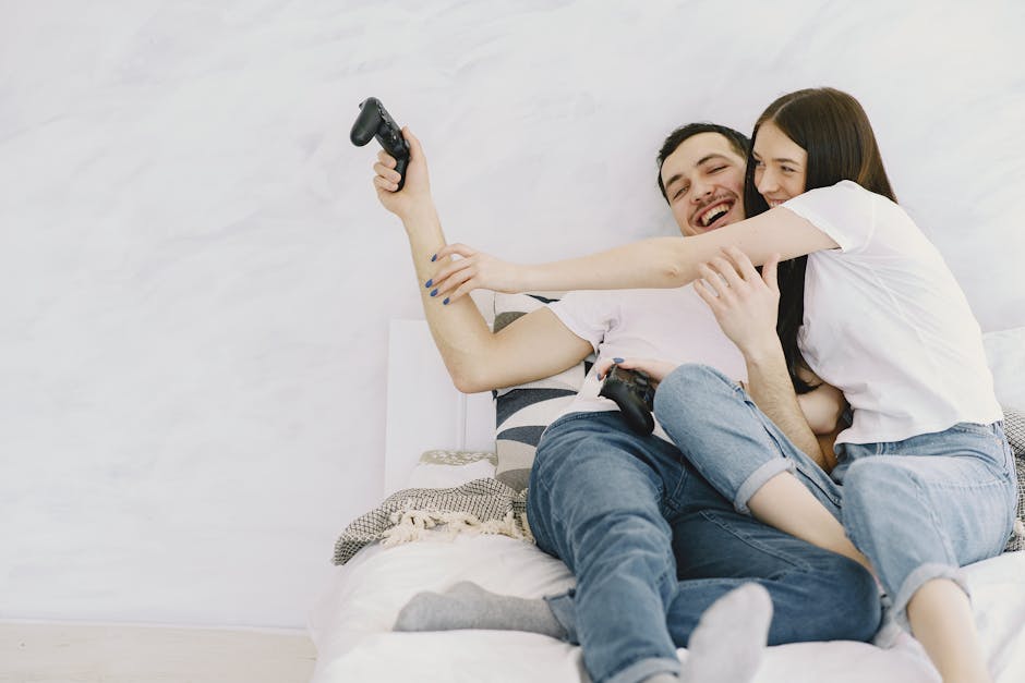 A cheerful couple having fun playing video games in bed, enjoying leisure time together.