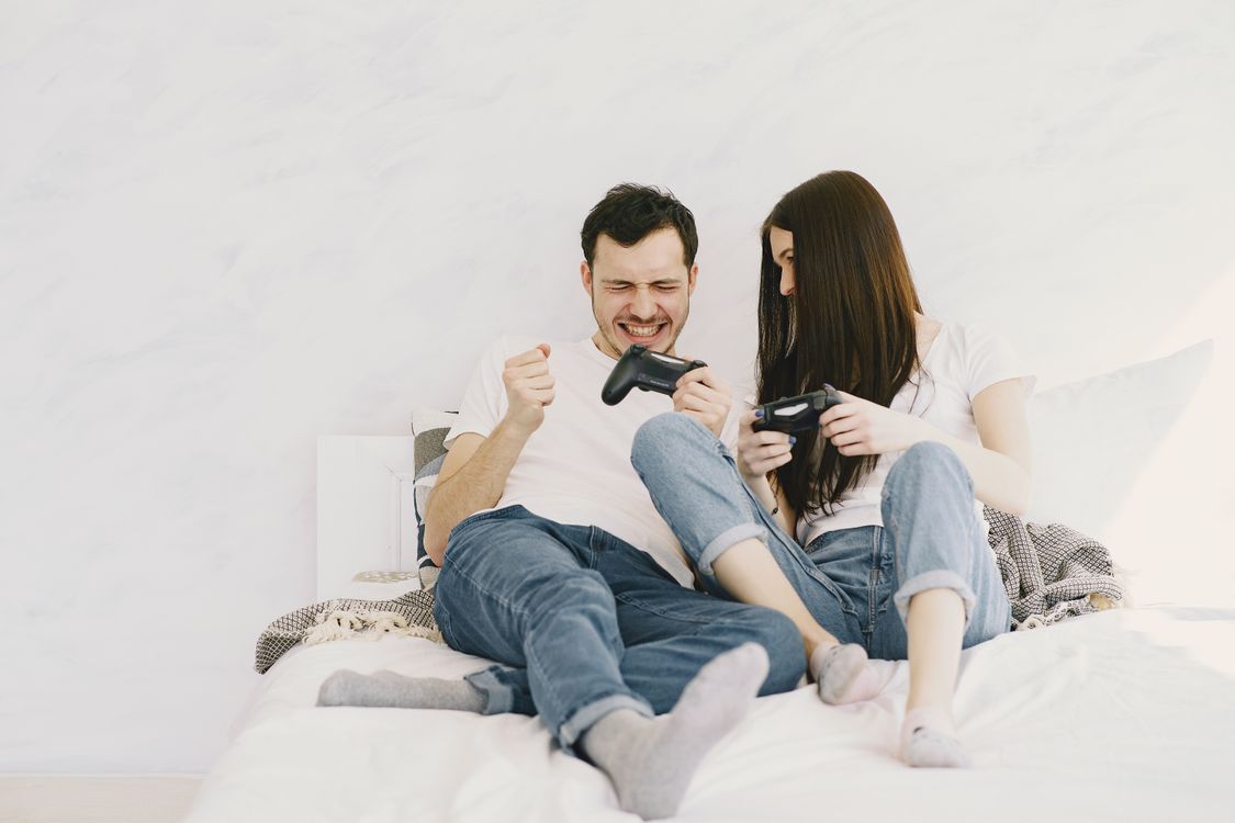 Cheerful couple spending time together while playing game console ...