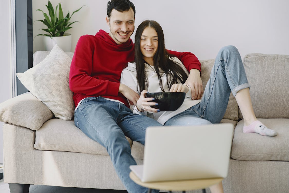Free Happy couple watching movie on laptop in apartment Stock Photo
