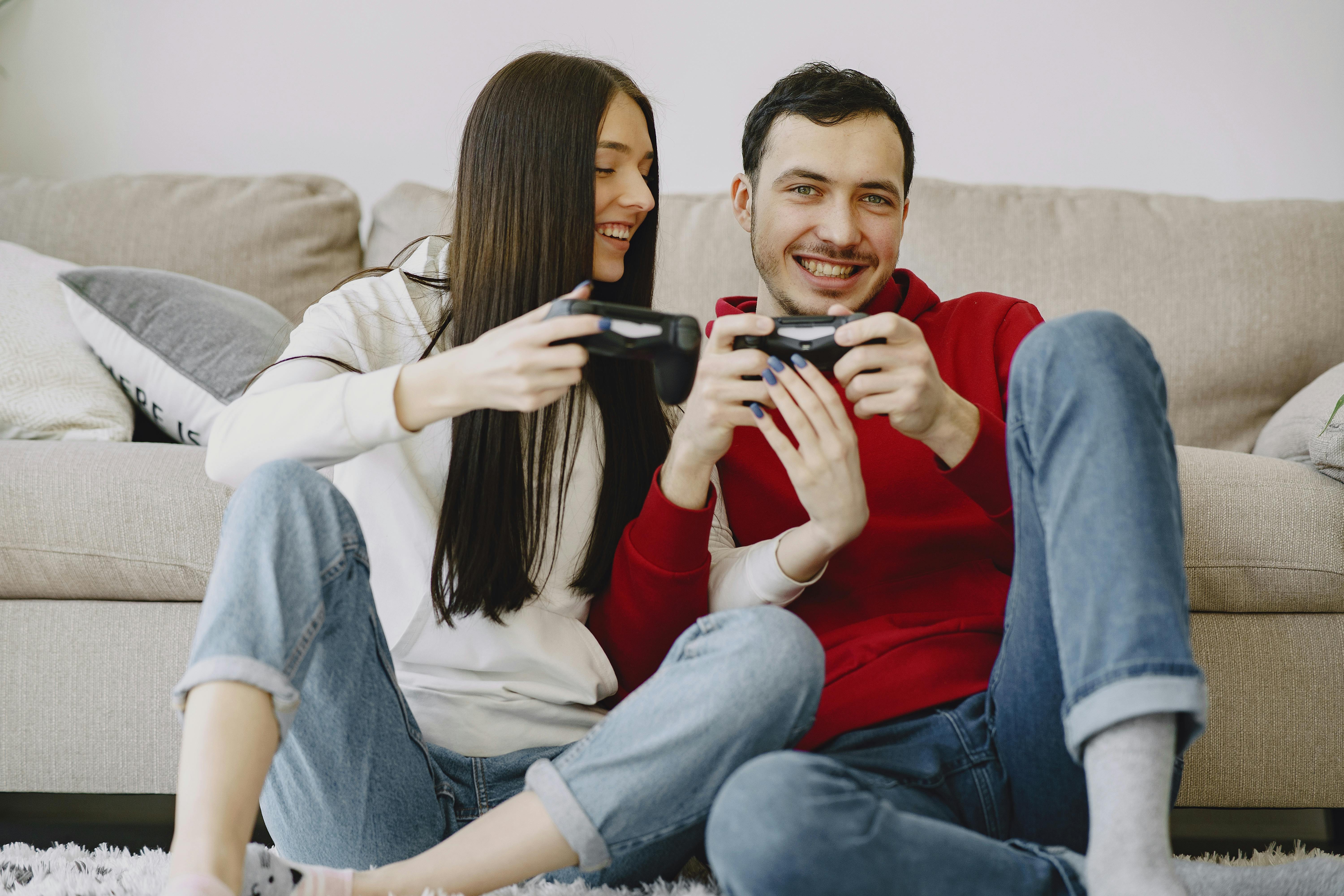 happy couple sitting on carpet while playing videogame