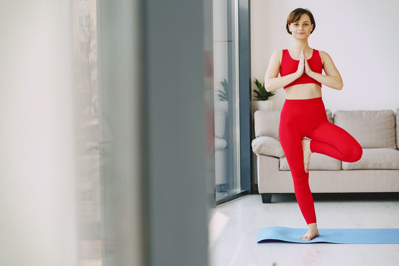 Woman in activewear standing on one leg practicing a balance yoga pose