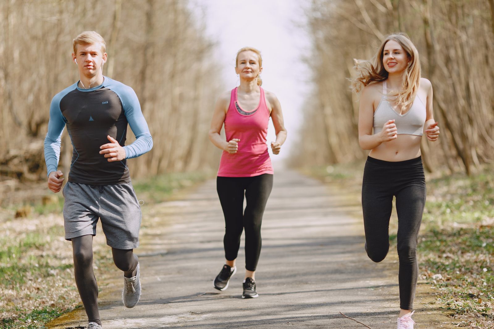 Adults jogging together on a tree-lined path