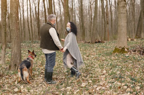 Man and Woman Walking With Dog on Forest