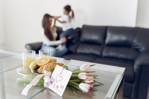 Shallow Focus Photo of Pink Tulips and Love Letter on Table