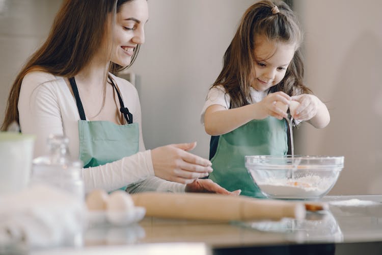 Photo Of Mom And Child Baking With Egg And Flour