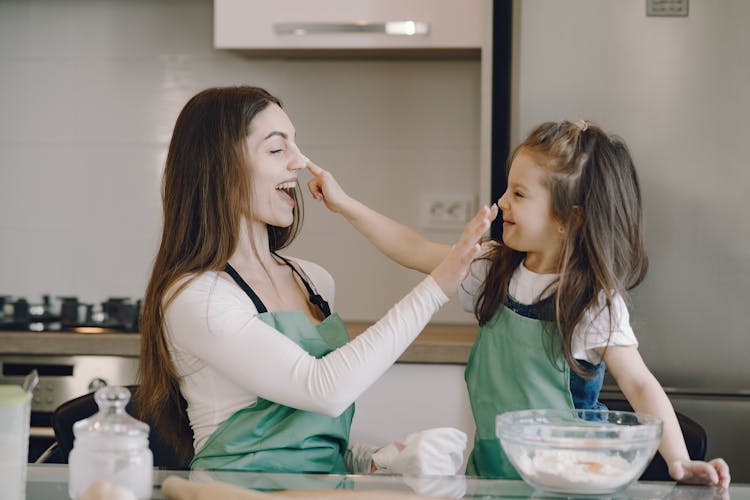 Woman And Kid Cooking Together On Kitchen