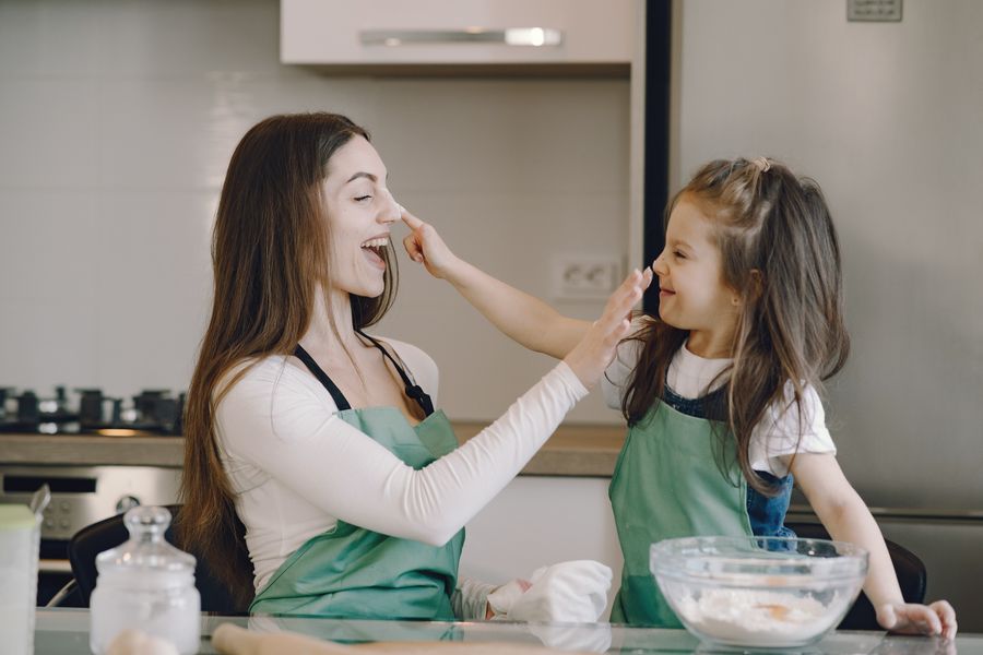 A child cooking alongside an adult