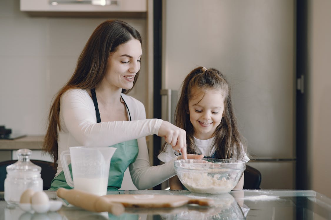 Free Photo of Woman and Child Smiling While Baking Stock Photo