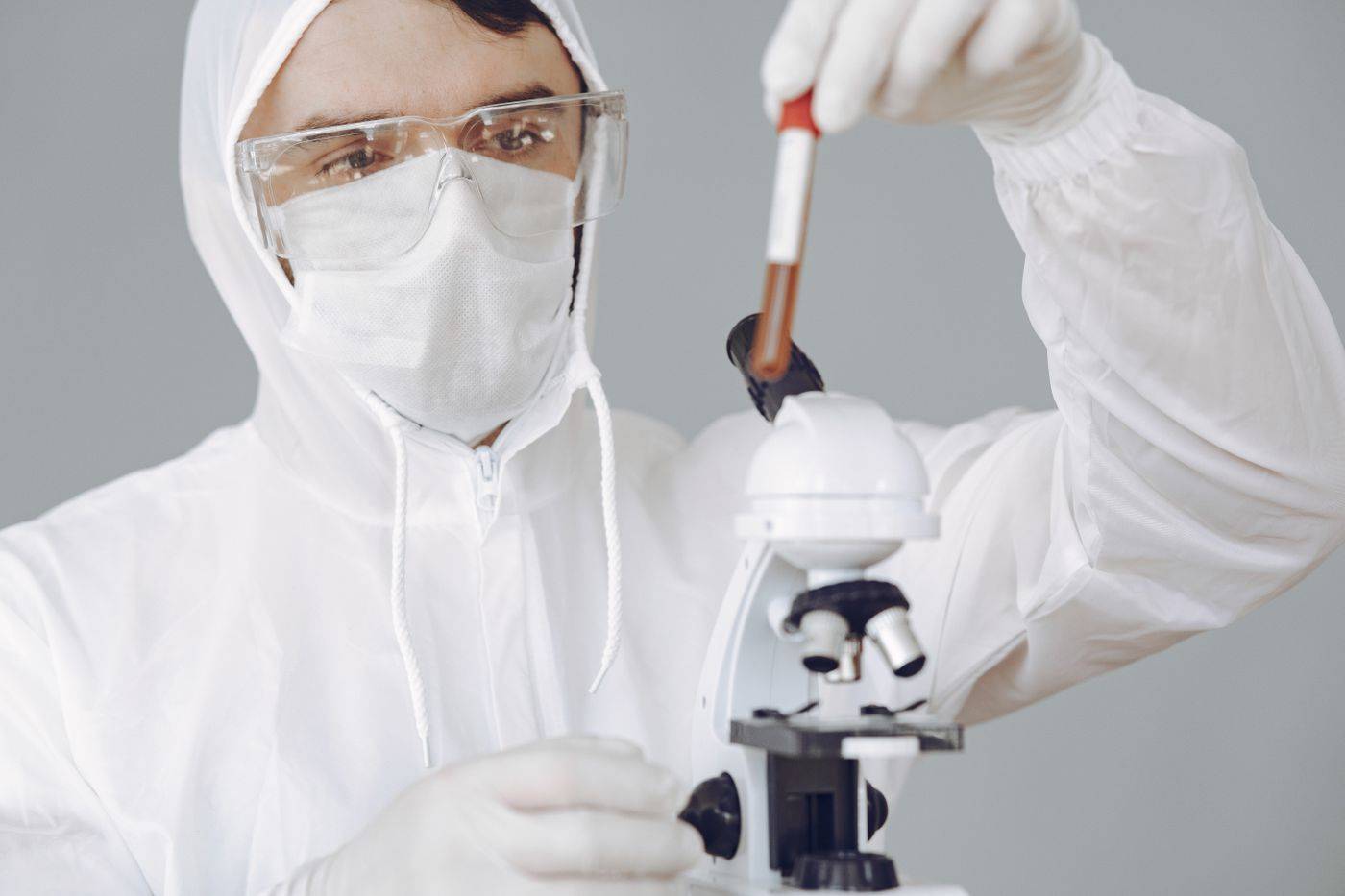 A laboratory professional examining a blood sample with a microscope