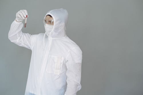 Person in Personal Protective Equipment Holding Test Tube