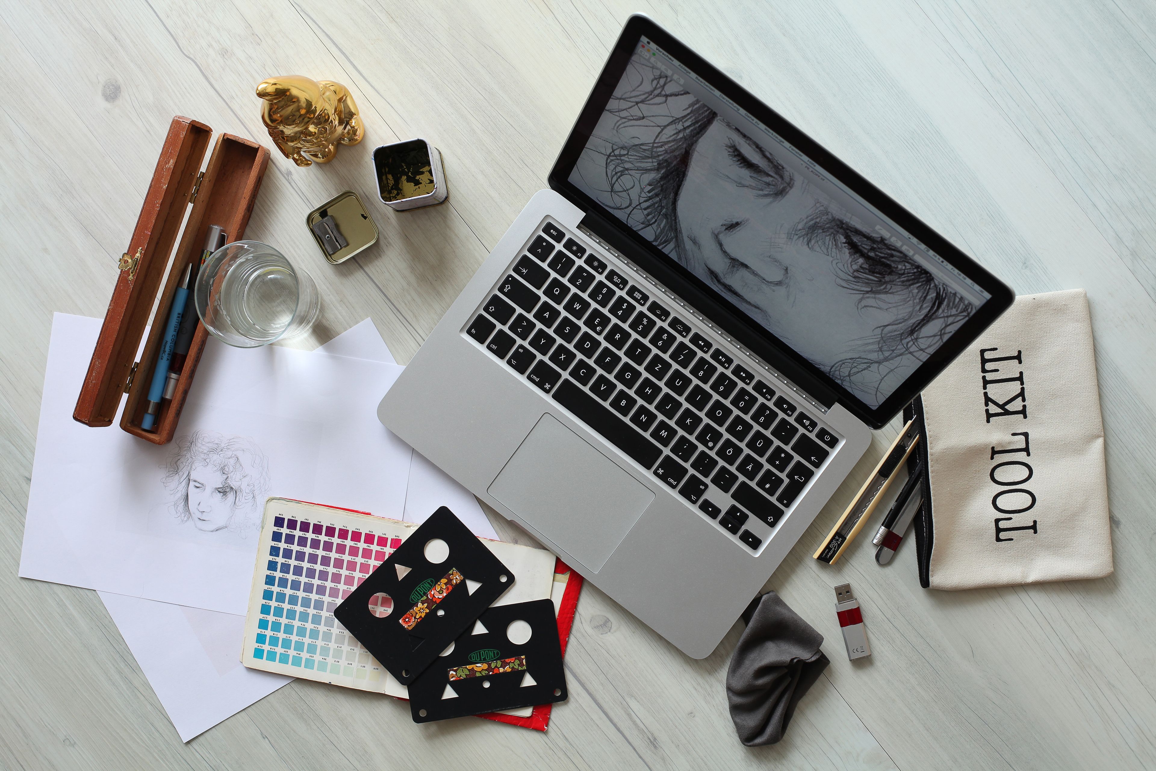 The desk: laptop, sketches and a paint palette