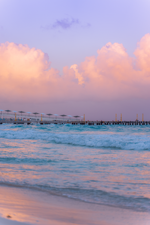 Free Stunning sunset scene at Playa del Carmen with pastel clouds and gentle waves. Stock Photo