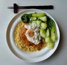 Delicious noodles with bok choy and fried egg on plate