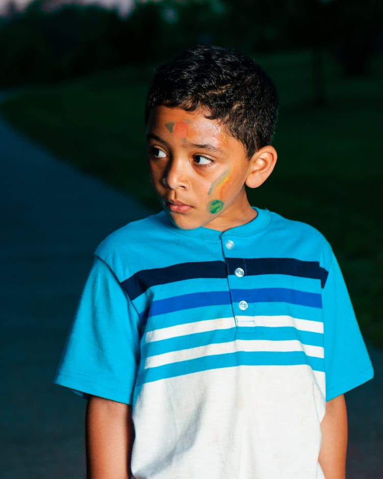 Concentrated Ethnic Boy With Dirty Face In Darkness