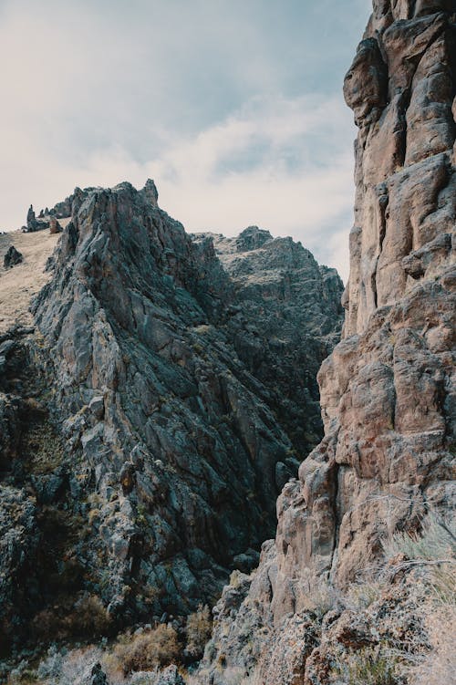 Scenery view of bristly mounts with dry uneven surface under sky with clouds in daytime