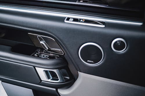 From above of modern style auto interior with plastic panel on door with handle with lock and round shaped buttons