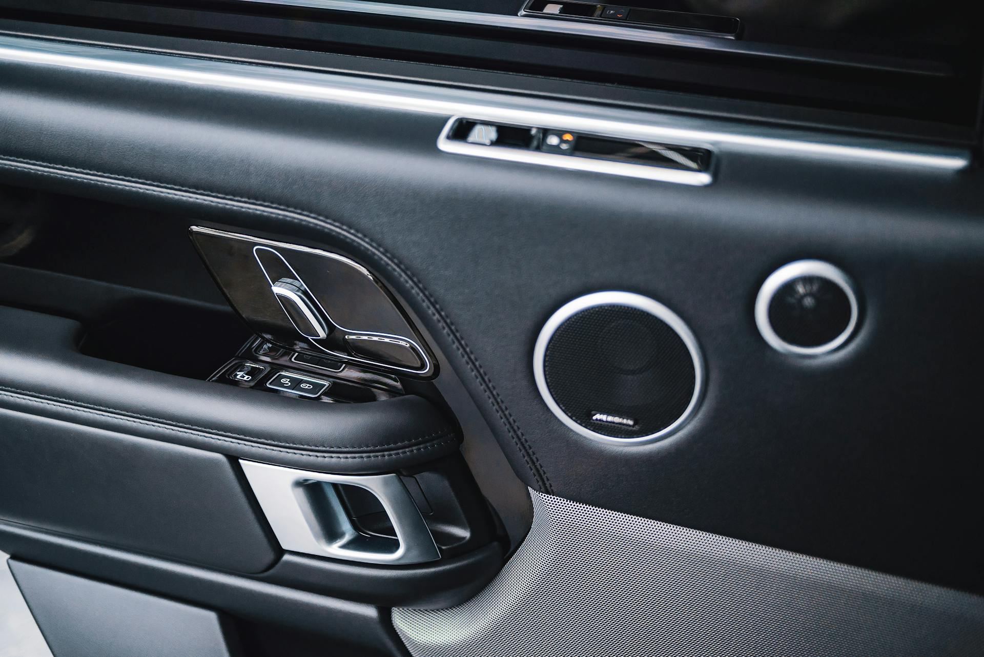 From above of modern style auto interior with plastic panel on door with handle with lock and round shaped buttons