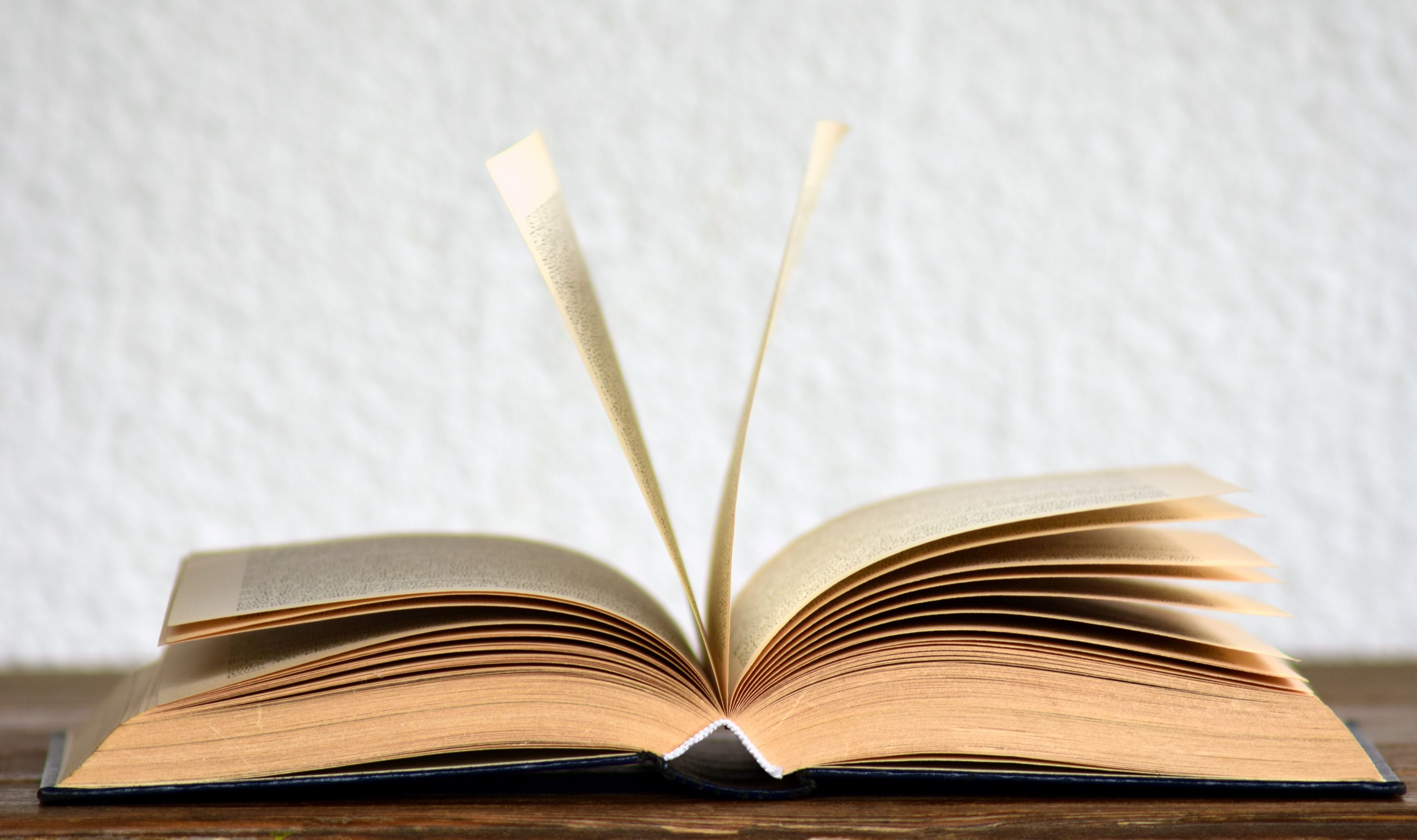 Open textbooks in front of a bookshelf