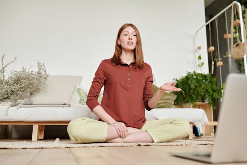 Woman in Red Long Sleeve Shirt and Yellow Pants Sitting on Rag