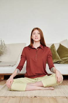 A serene woman practicing yoga in a cozy living room setting, focusing on mindfulness and relaxation.