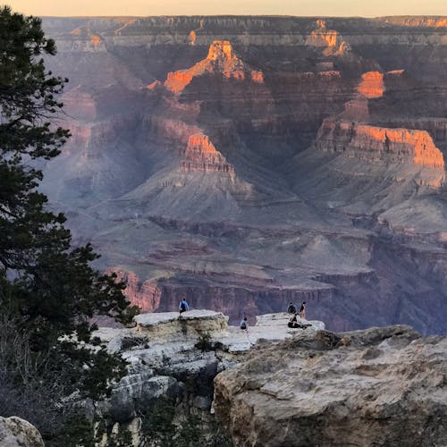 People on Top of Gray Rock Formation