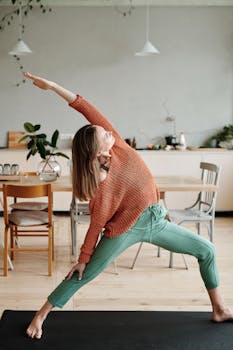 Woman practicing yoga pose indoors in a modern, cozy home with wooden furniture.