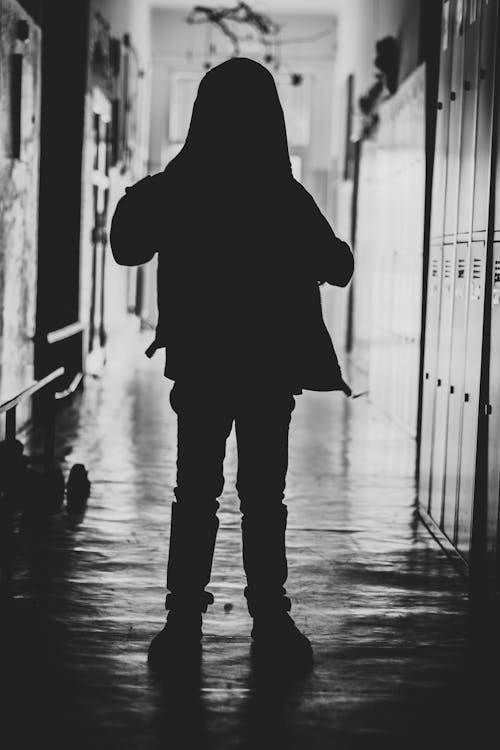 Silhouette Photography of Toddler Standing Beside Locker