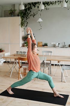 Woman practicing yoga indoors on a yoga mat, enhancing flexibility and wellness.