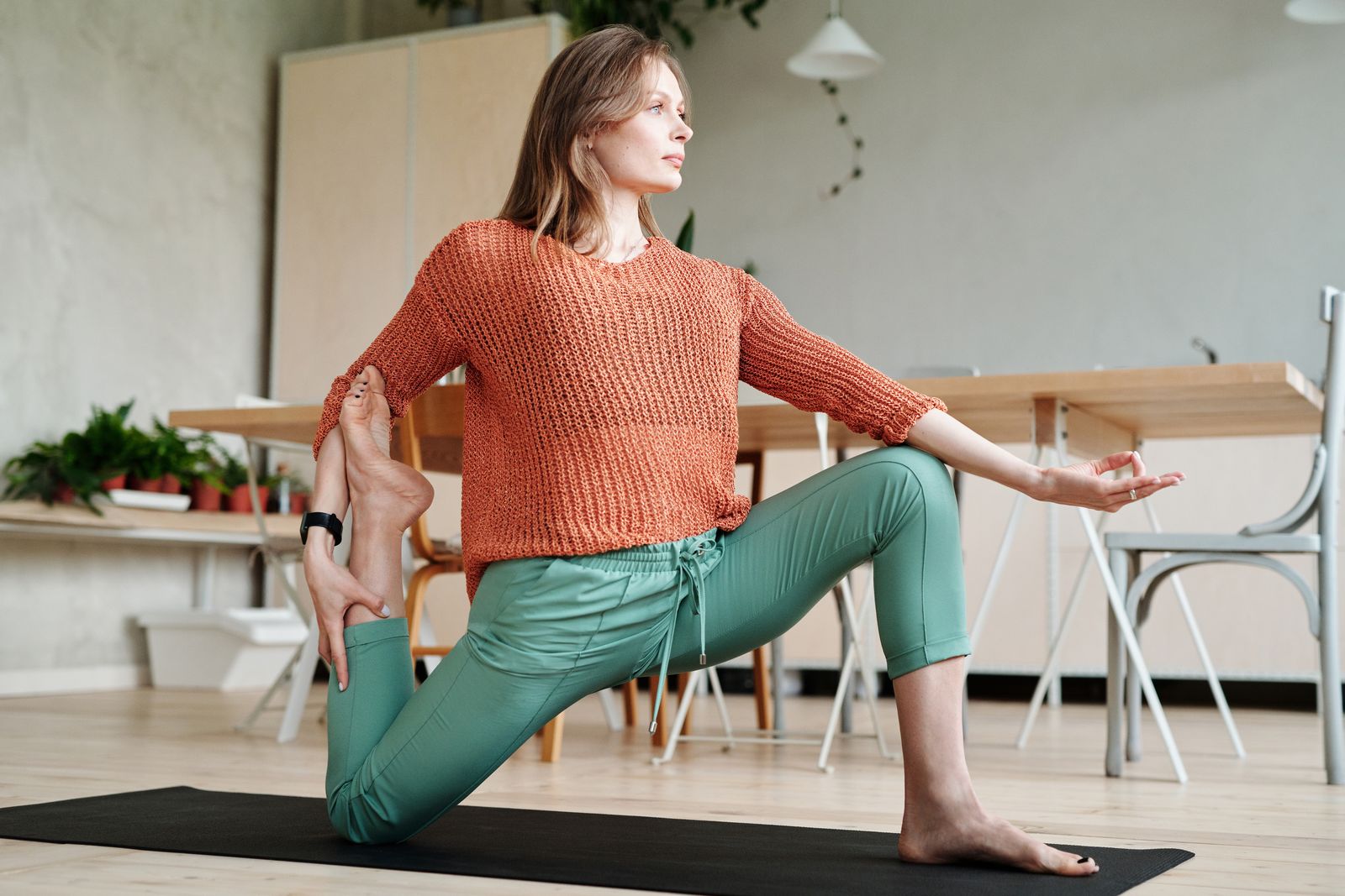 Woman kneeling gently on a yoga mat while practicing a knee-friendly yoga pose