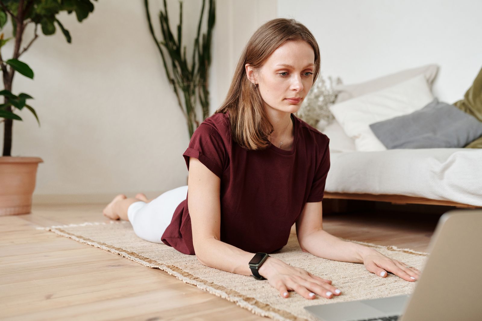 Office worker stretching on a yoga mat next to a laptop, balancing work and wellness