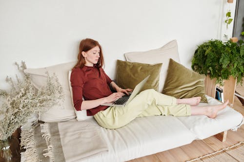 Wanita Berkemeja Lengan Panjang Merah Duduk Di Sofa Putih