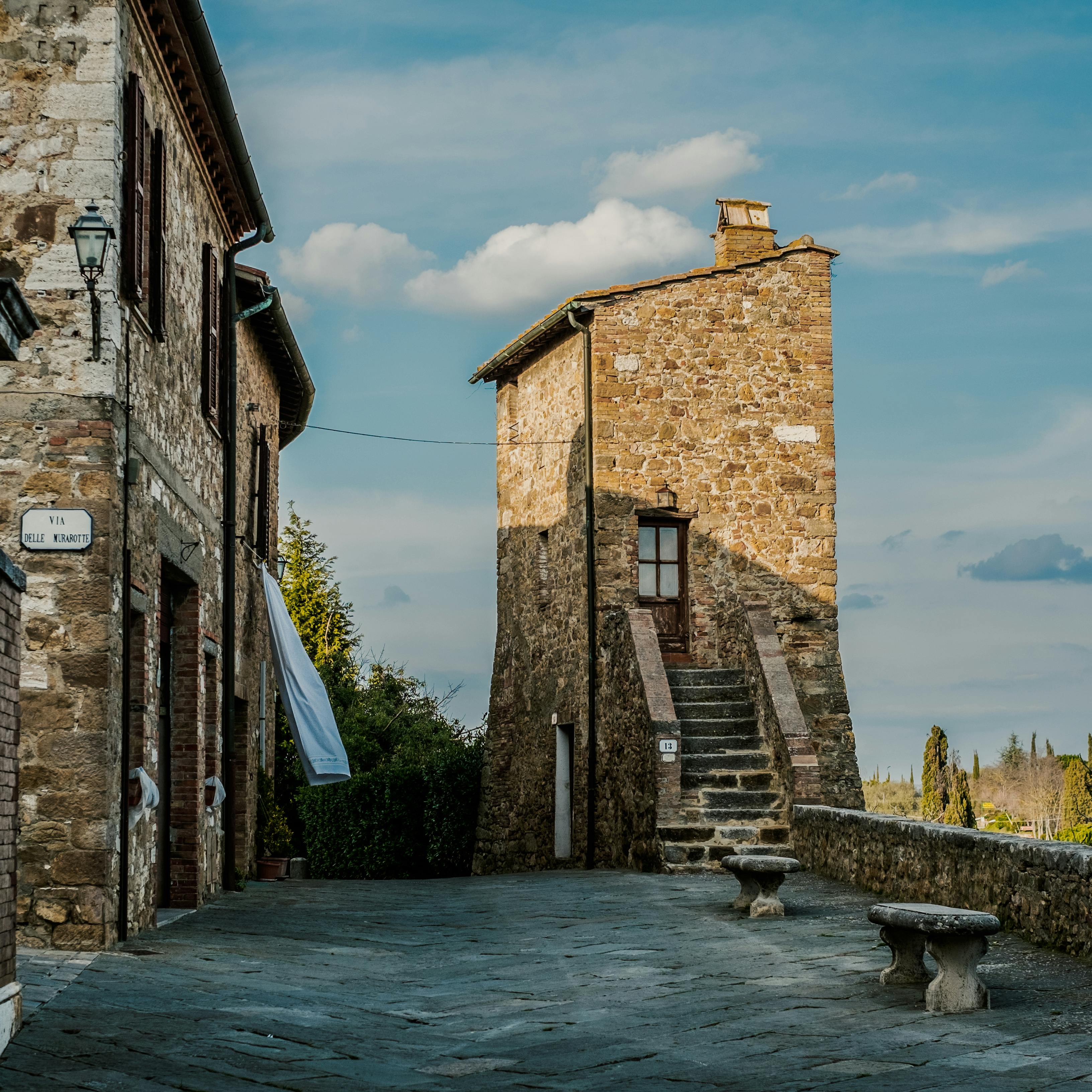 Charming stone village buildings under a bright sky in Tuscany, Italy.