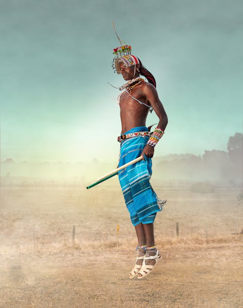 Woman in Blue and White Skirt Holding Stick