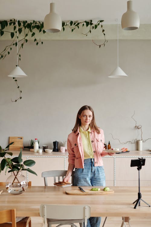 Woman in Pink Jacket Holding White Plate