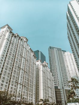 A modern cityscape featuring towering high-rise buildings under a clear blue sky.