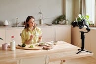 一名女子在现代厨房里录制健康早餐视频博客，其中包含鳄梨