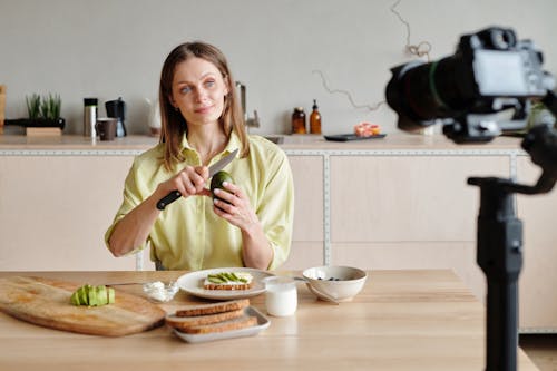 Woman Looking at the Camera While Peeling the Avocado 