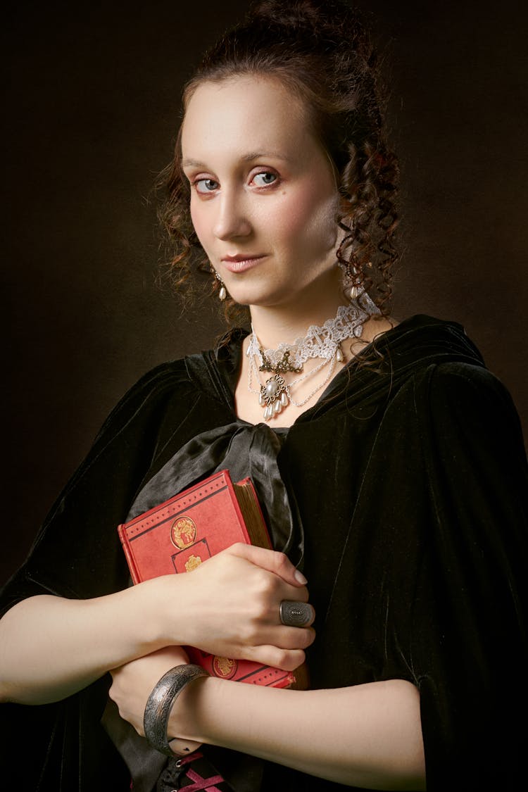 Renaissance Style Woman With Accessories And Book On Black Background