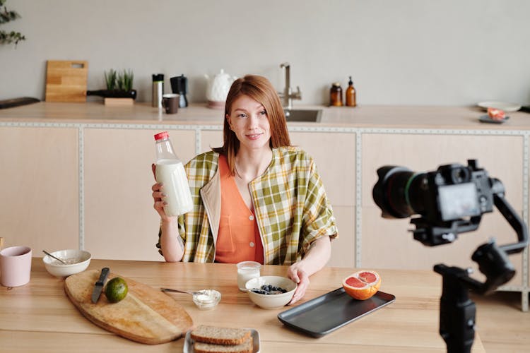 A Woman Holding A Jar Of Milk