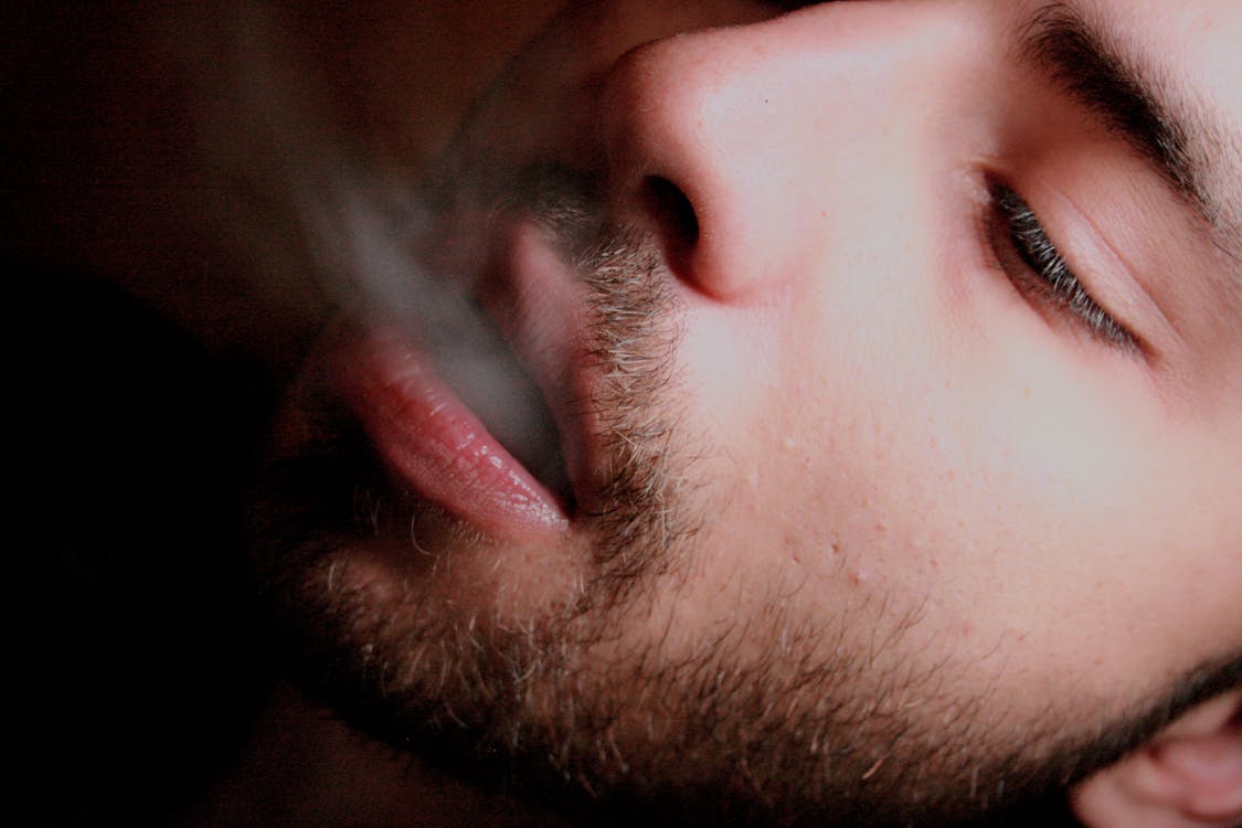 無料 煙を吹く男のクローズアップ写真 写真素材