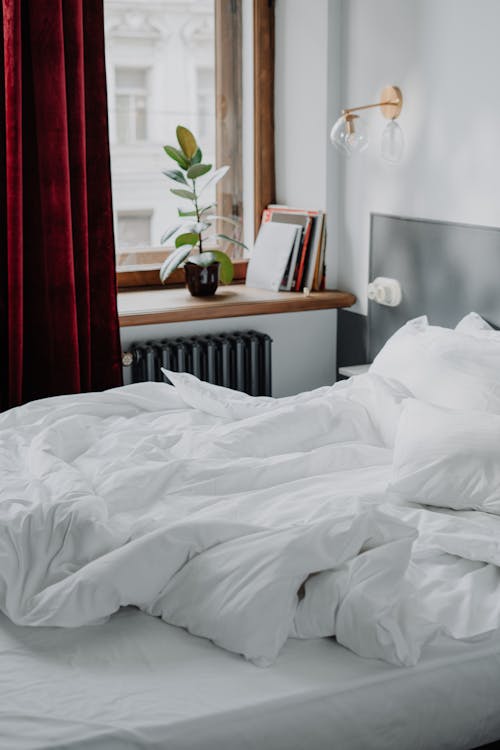 Free White Bed Linen Near White Heater Radiator Stock Photo