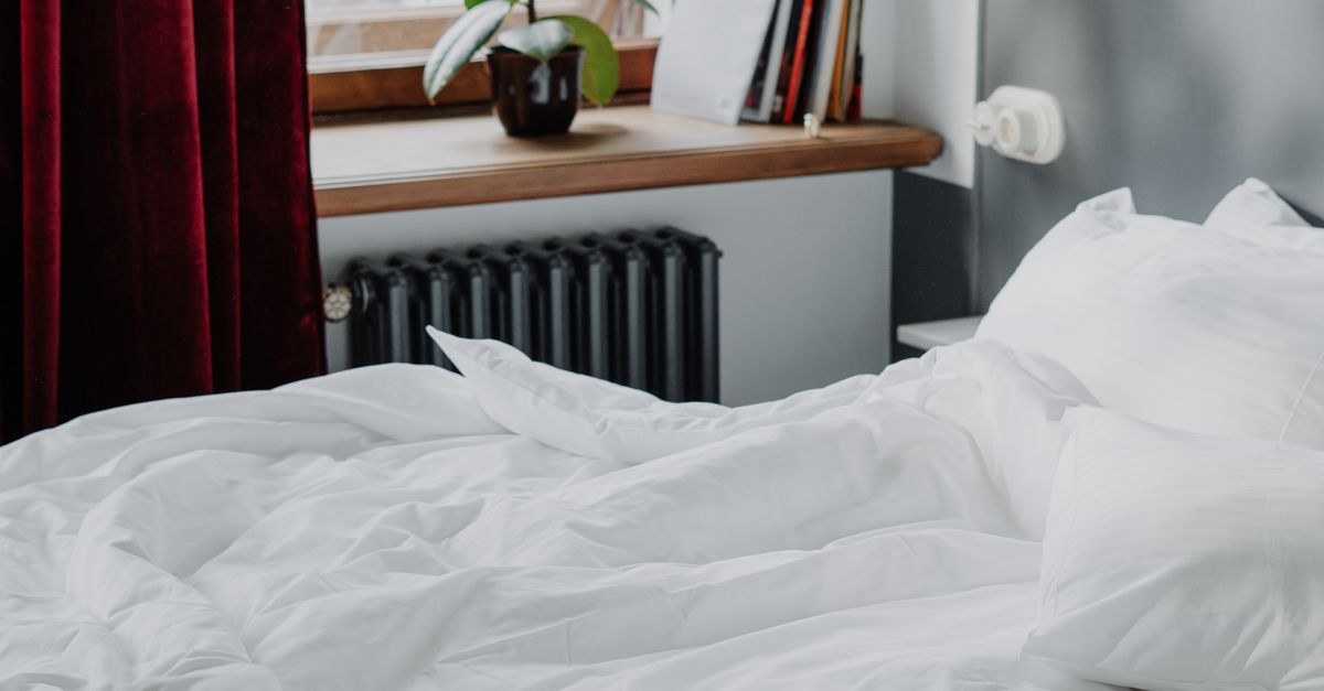 White Bed Linen Near White Heater Radiator · Free Stock Photo