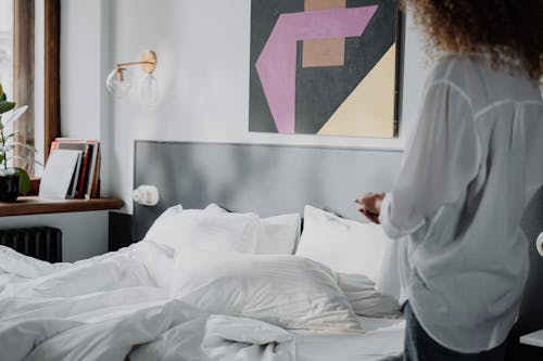 Free Woman in White Robe Standing Beside Bed Stock Photo