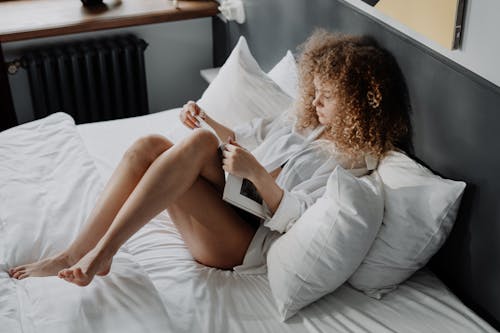 Free Woman in White Dress Shirt Reading Book Stock Photo