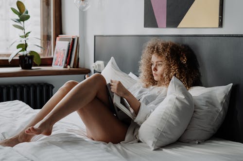 Free Woman in White Dress Lying on Bed Stock Photo