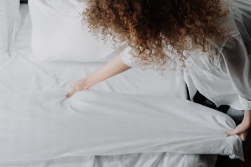 Woman in White Dress Lying on Bed