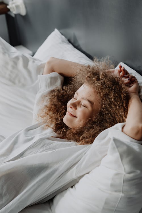 Free Woman in White Dress Lying on Bed Stock Photo